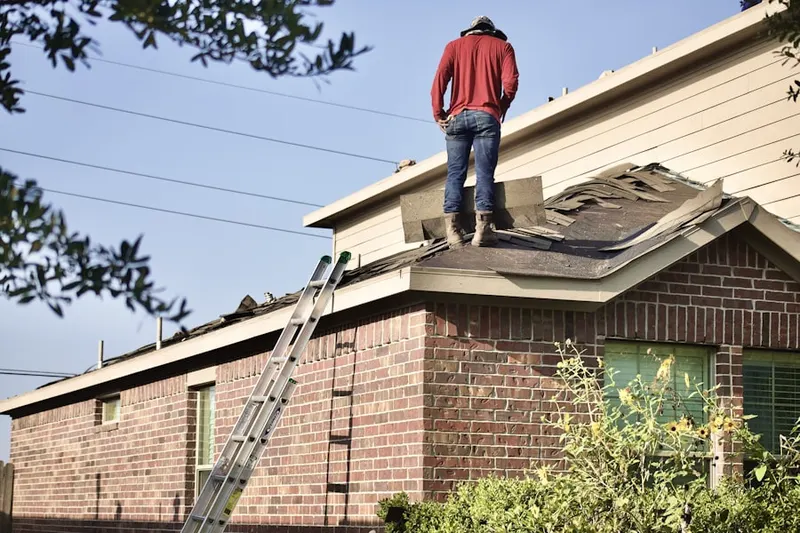 Professional roofer working on a residential roof in Claryville
